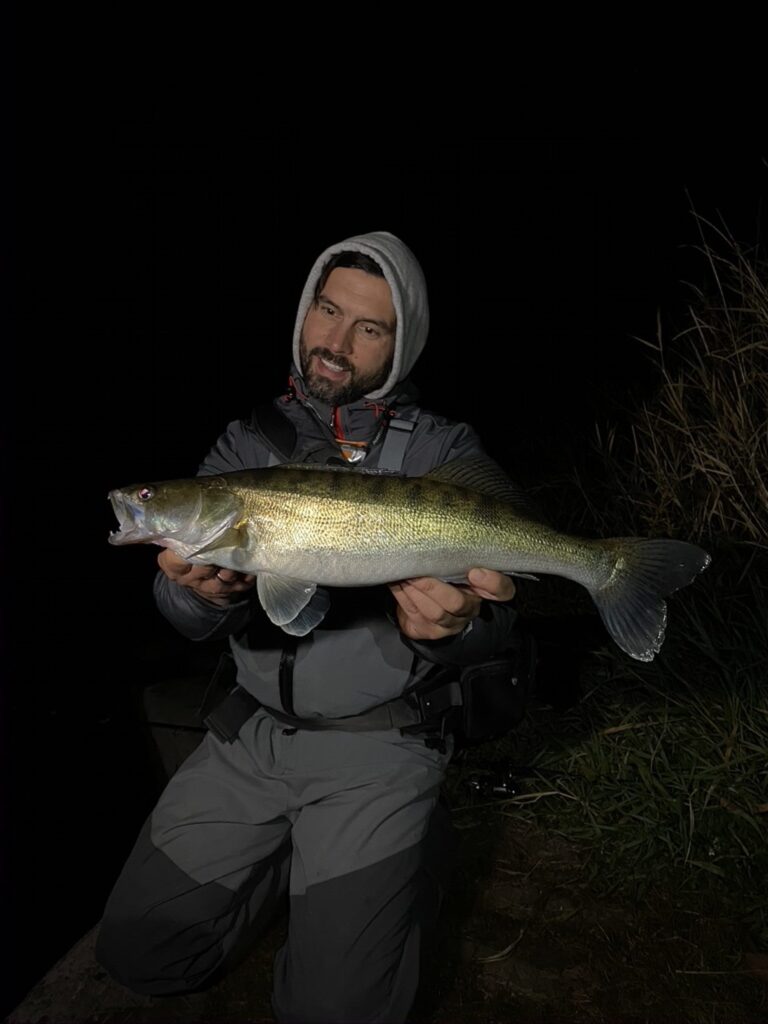 Zander beim Angeln in der Nacht am Fluss