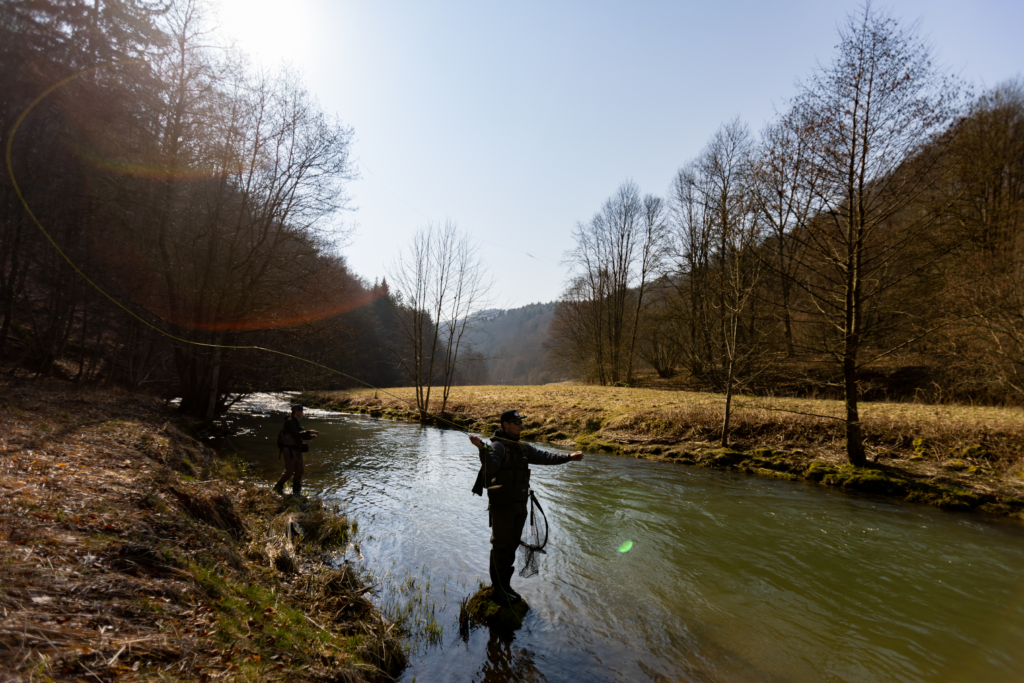 Malerische Natur mit zwei Fliegenfischern im Bach